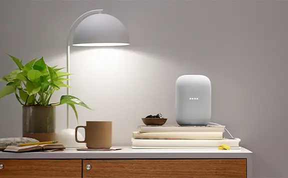 Google Home sitting on table with desk light