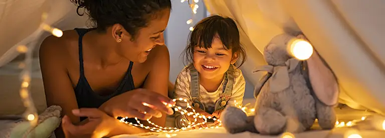 Mom and daughter in a fort with string lights