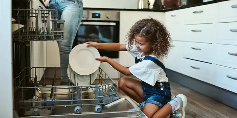 Mother daughter loading dishwasher