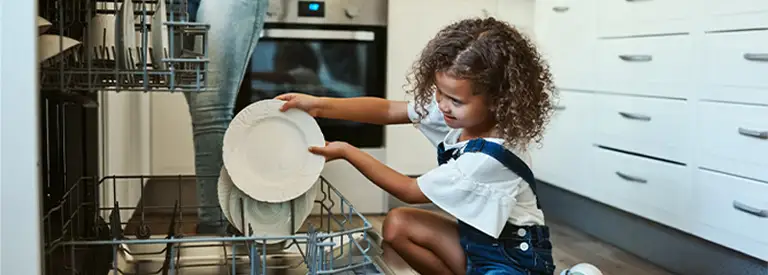 Mother daughter loading dishwasher