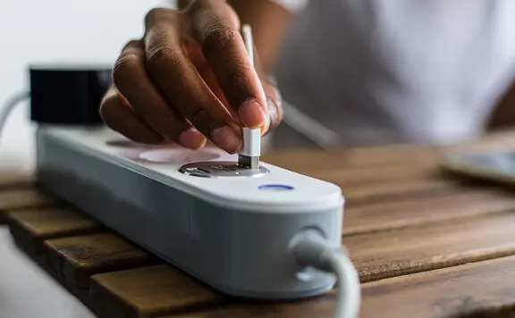 Hand plugging into smart power strip for energy
