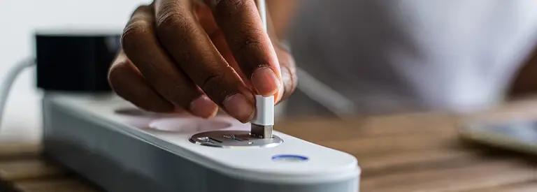 Hand plugging into smart power strip for energy