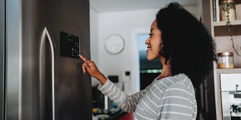 Woman using smart refrigerator at home