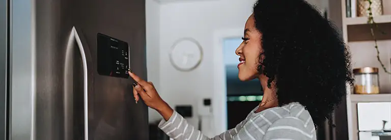 Woman using smart refrigerator at home