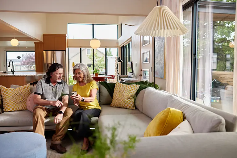 couple looking at a phone on their couch