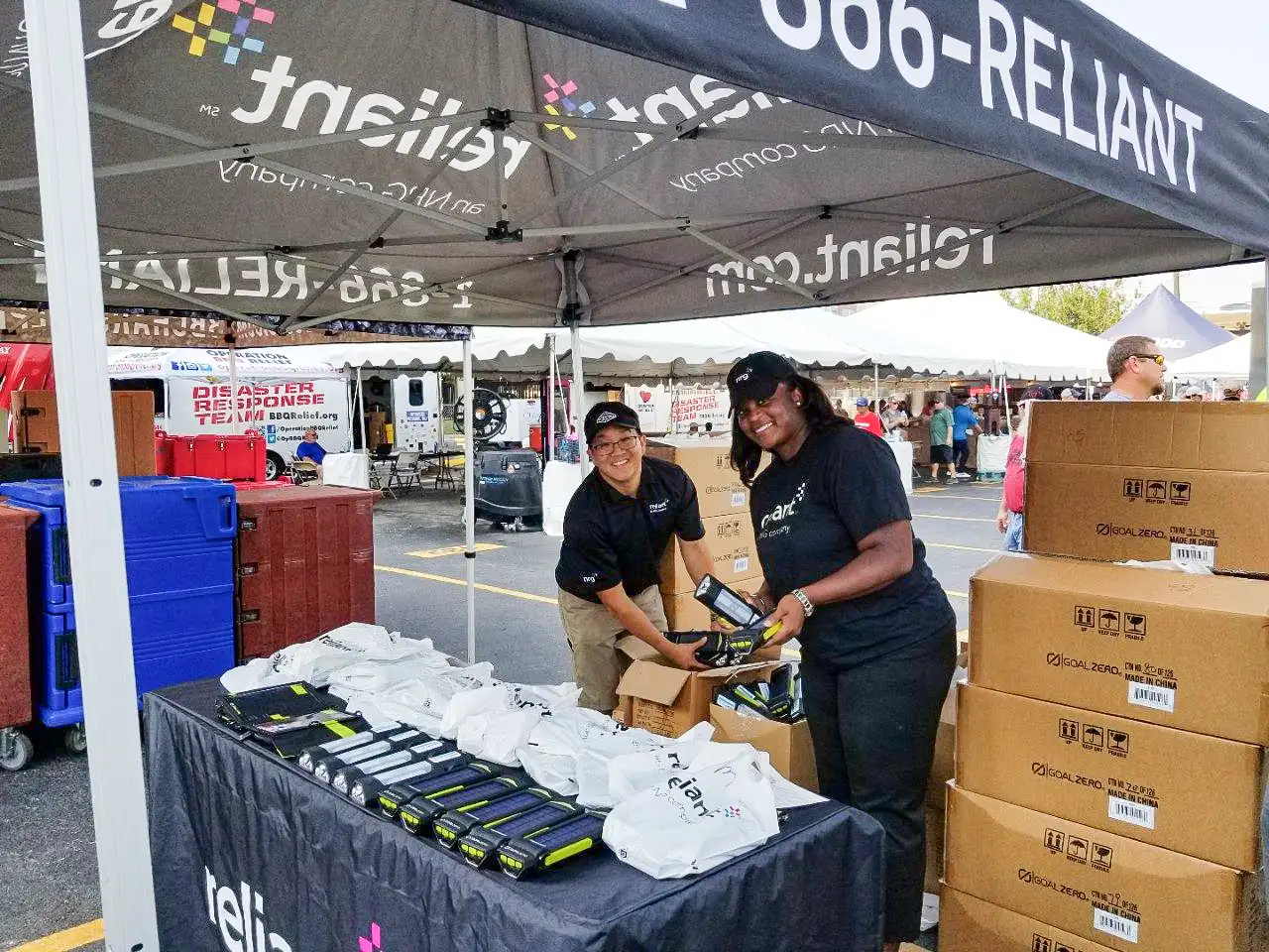 Two volunteers at an outdoor Reliant charitable event