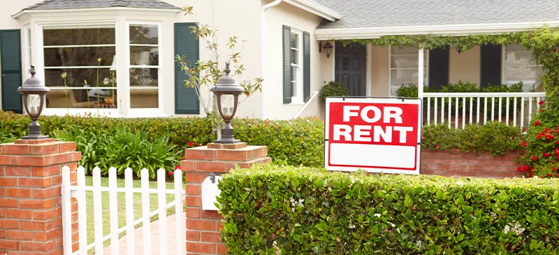 House with a For Rent sign in front of it