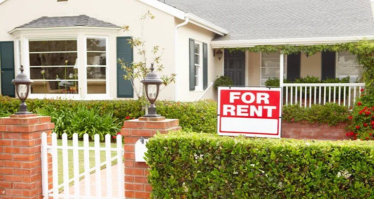House with a For Rent sign in front of it
