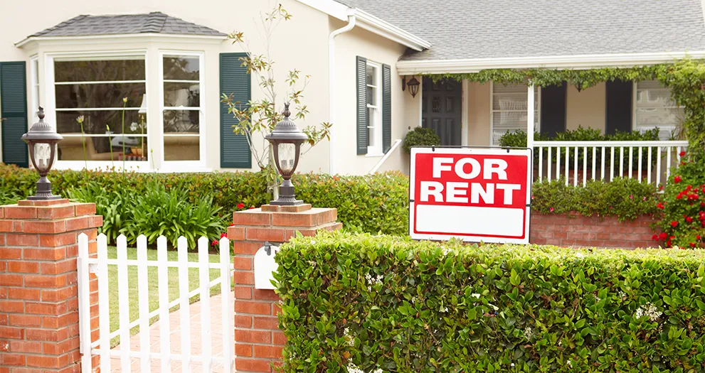 House with a For Rent sign in front of it