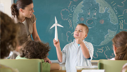 Young student in classroom presenting wind turbine