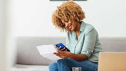 woman-using-phone-paying-bills