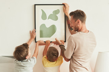 father-and-children-hanging-a-picture.